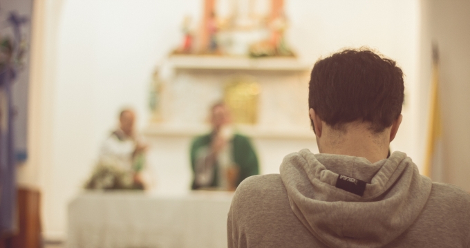 joven orando misa